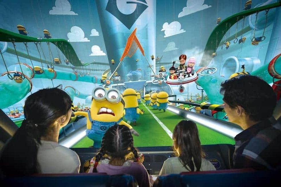 Family enjoying a Minions-themed ride with immersive animated scenes.