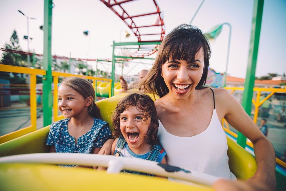 Family enjoying a roller coaster ride, smiling and excited.