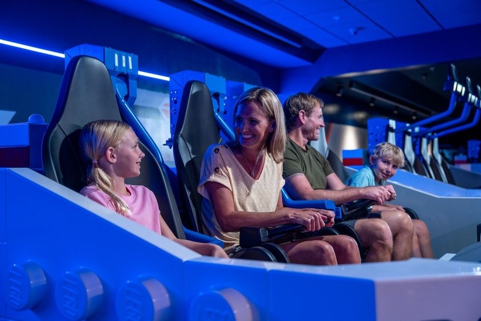 Family enjoying a theme park ride with futuristic blue lighting.