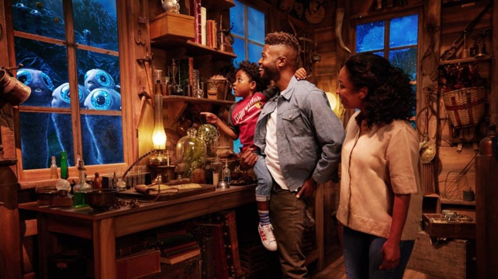 Family in cabin watches curious creatures peering through window at night at Warner Bros. Studio Tour Hollywood