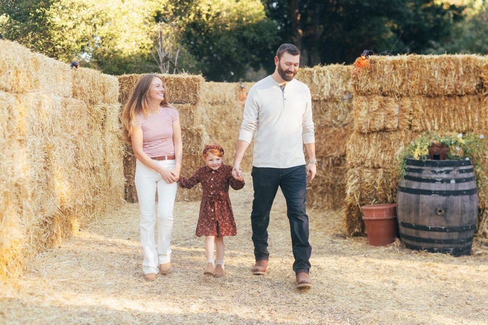 Family walking through a hay maze, holding hands and smiling on a sunny day at Filoli