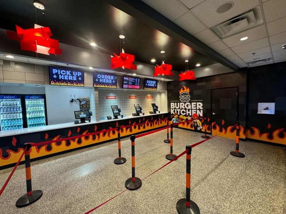 Fast-food counter with flame decor, red lights, and "Burger Kitchen" sign.