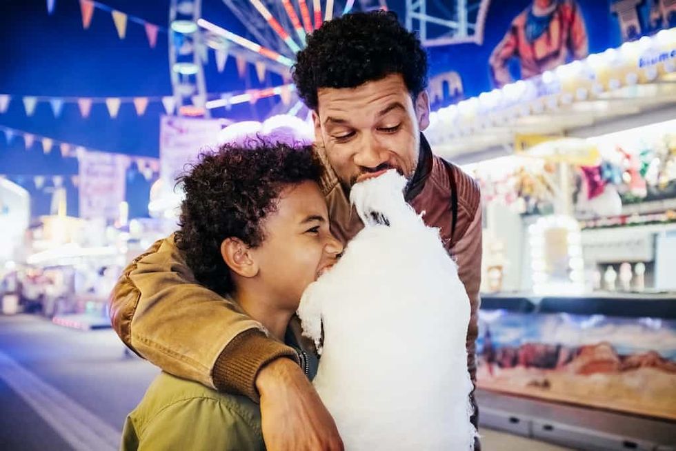 Father-and-son-eat-candy-floss-at-amusement-park