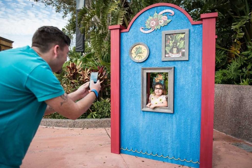 Father takes picture of his daughter posing as Frida Kahlo at Epcot's International Festival of the Arts