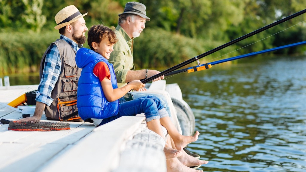 Fishing all together. Men of three generations enjoying morning while fishing all together