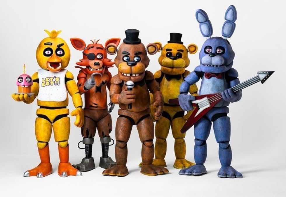 Five colorful animatronic characters, including a bear and rabbit, posed with instruments.