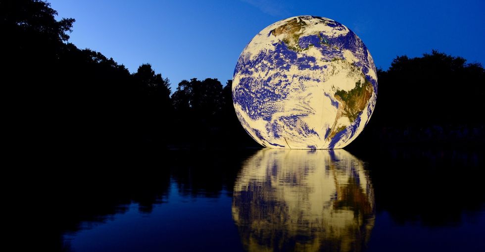 Floating Earth, Jersey, U.K. Queens valley reservoir. A floating 10 metre ball of our home planet, showing the fragility of our planet especially today during climate change.