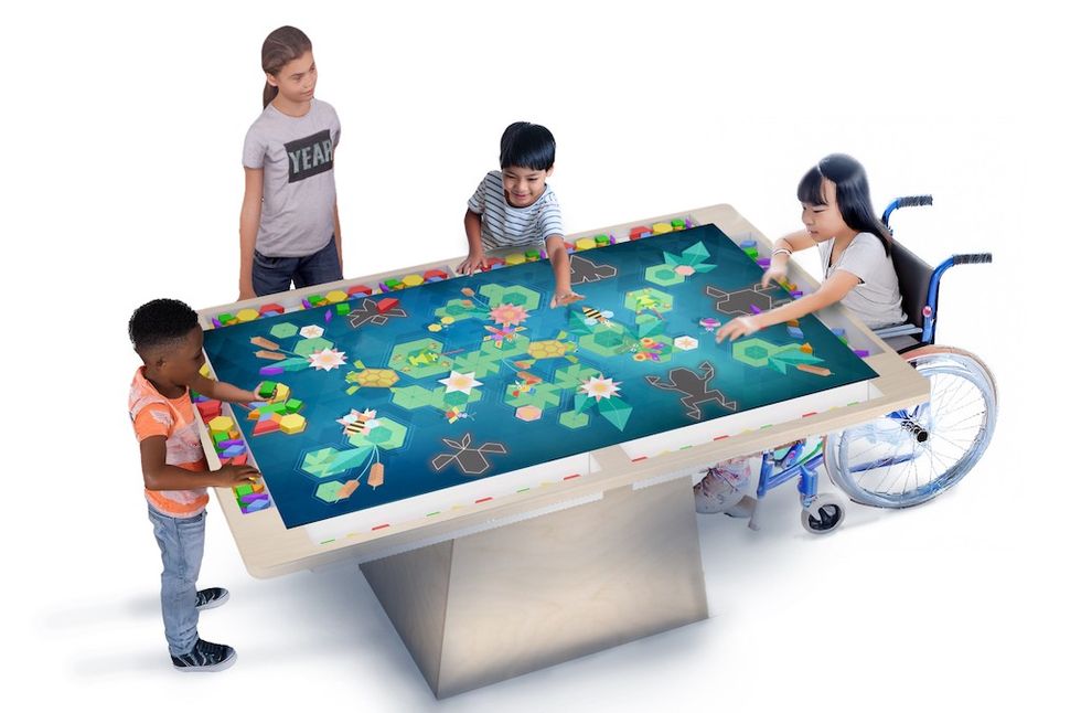 Four children playing with an interactive digital table.