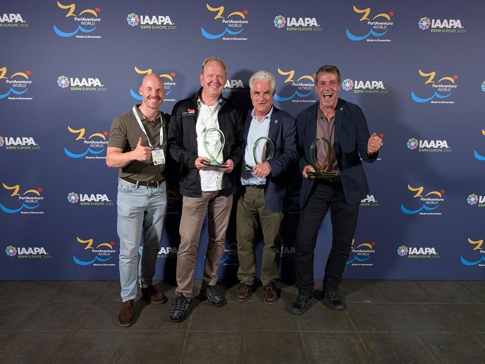 Four men holding awards, smiling at the IAAPA Expo Europe 2023 backdrop.