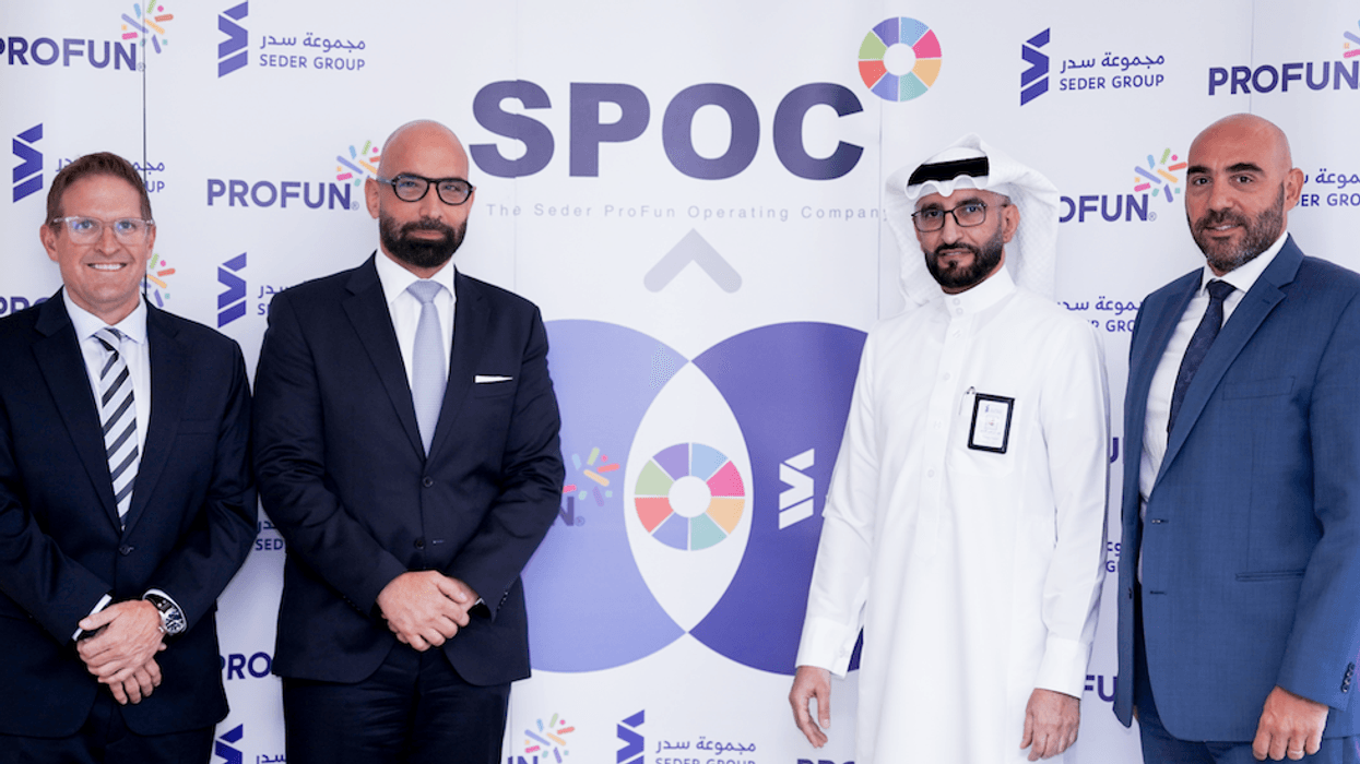 Four men in formal attire stand in front of a SPOC logo backdrop.