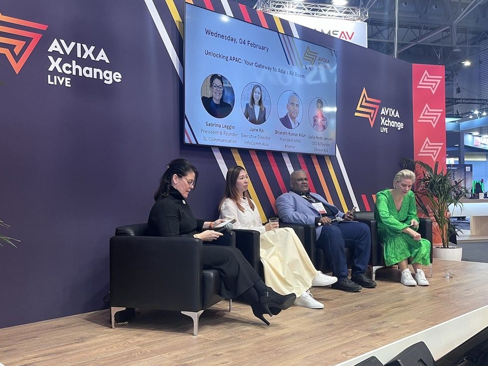 Four panelists seated on stage at AVIXA Xchange Live event.