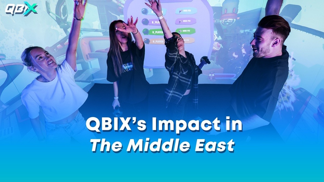 Four people celebrating in front of a vibrant digital display.