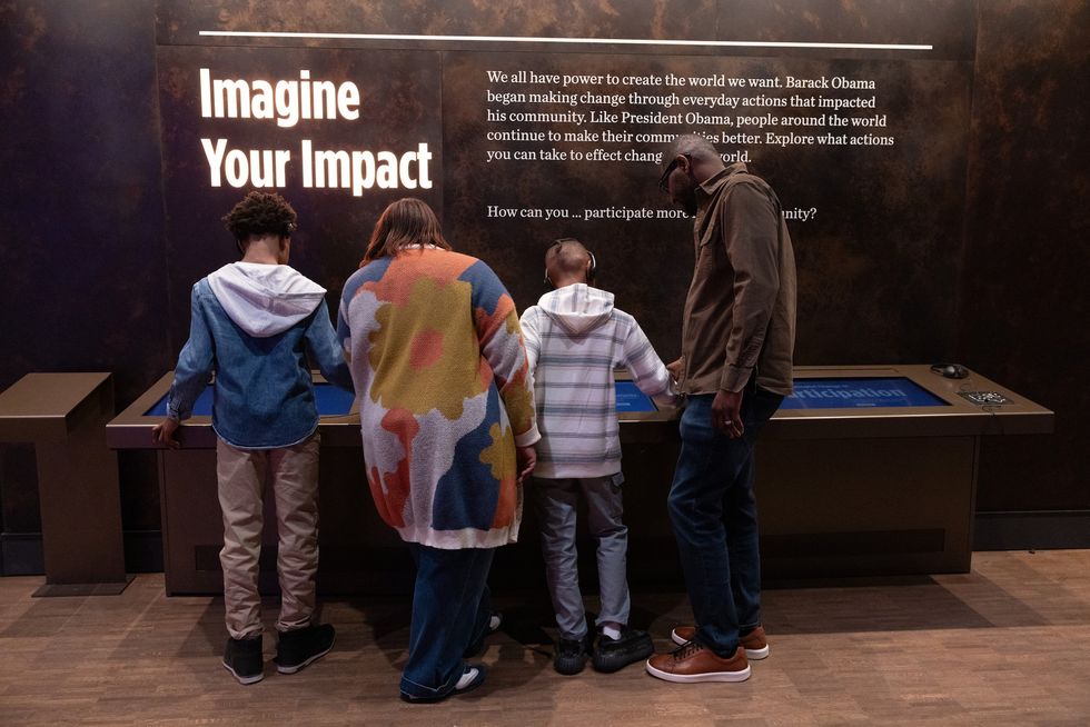 Four people read an exhibit titled "Imagine Your Impact" at Obama Presidential Center Museum