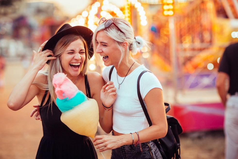 Friends laughing at theme park with candy floss
