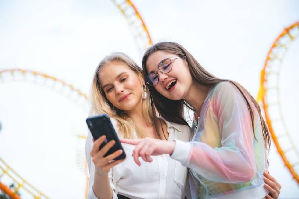 Friends-using-phone-at-theme-park visitor attraction SEO