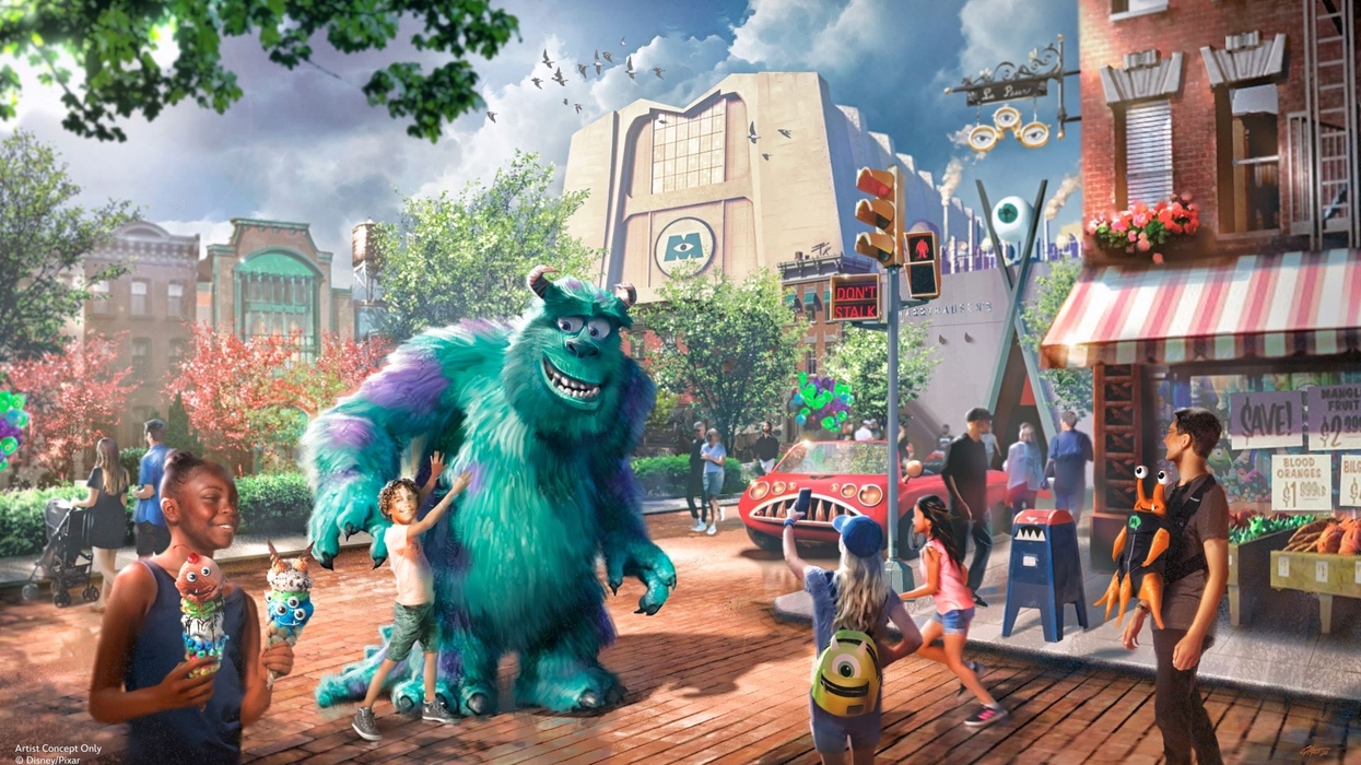 Furry blue monster with kids in a lively, colorful city street scene at the Monsters, Inc.-themed land at Disney World.