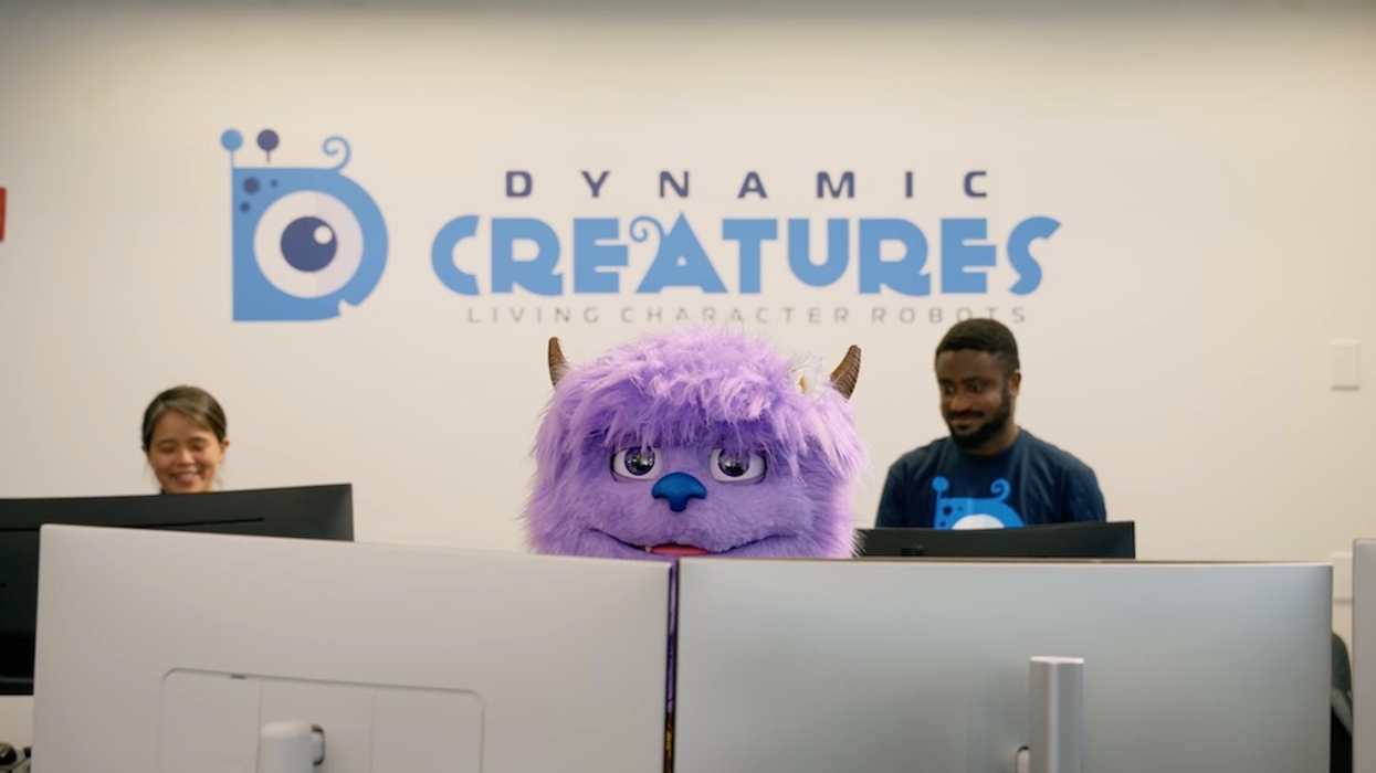 Furry purple creature at office desk with two people, under "Dynamic Creatures" sign.