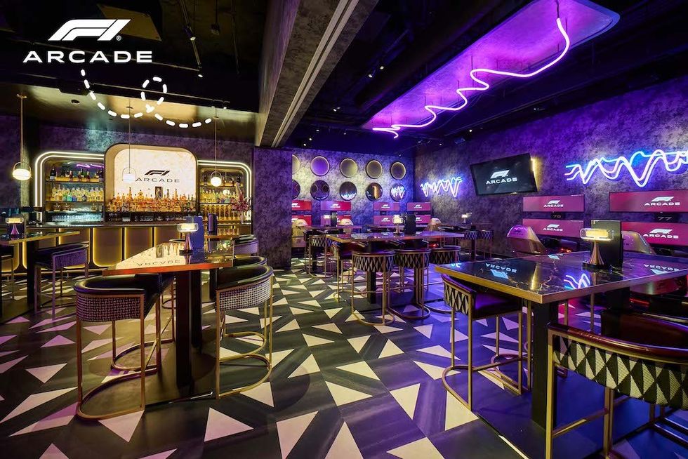 Futuristic arcade bar with neon lights and geometric flooring.