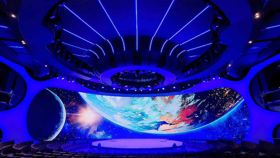Futuristic auditorium with a large Earth projection and blue neon lights.