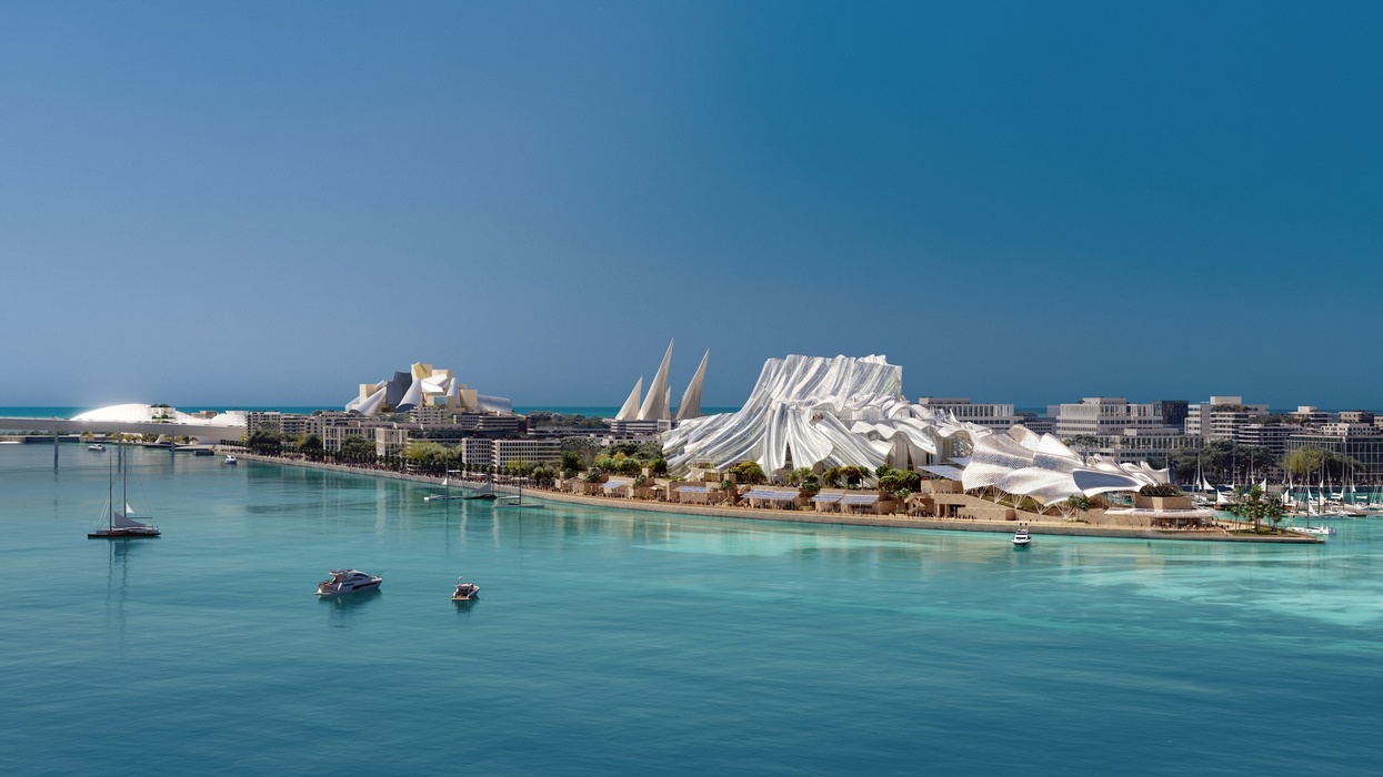 Futuristic coastline architecture with sailboats on turquoise water under a clear blue sky.