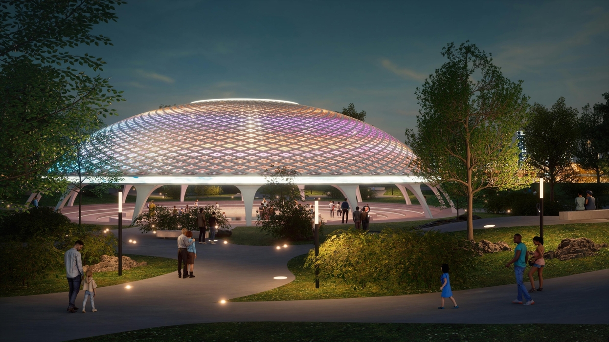 Futuristic dome at night with colorful lights, surrounded by people and trees.