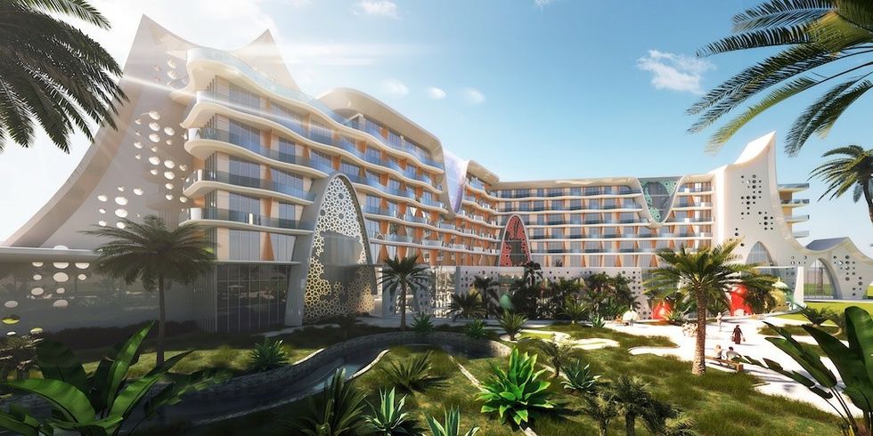 Futuristic hotel with curved architecture, surrounded by lush greenery and palm trees.
