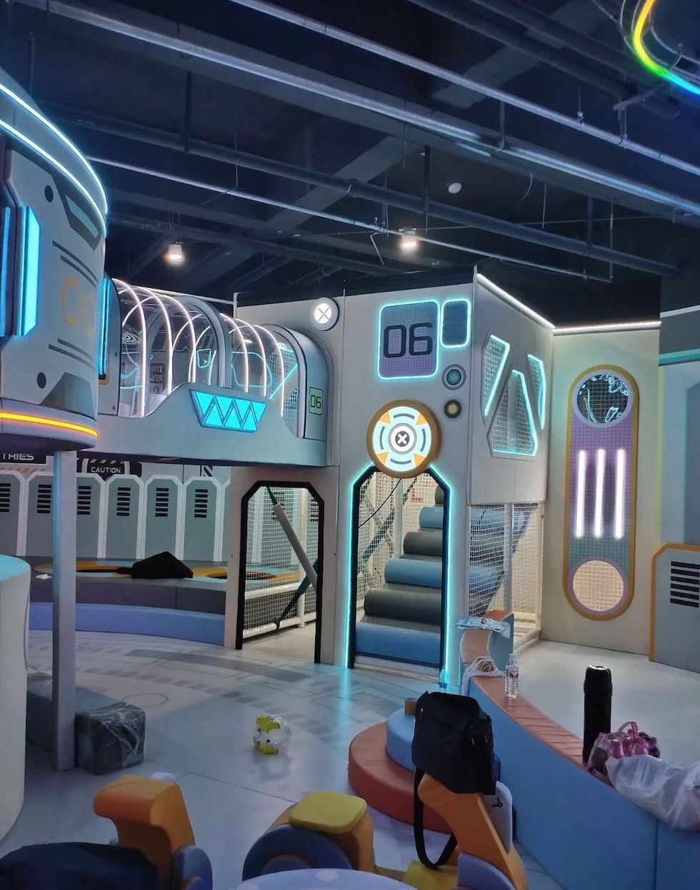 Futuristic indoor playground with neon lights and sci-fi design elements.