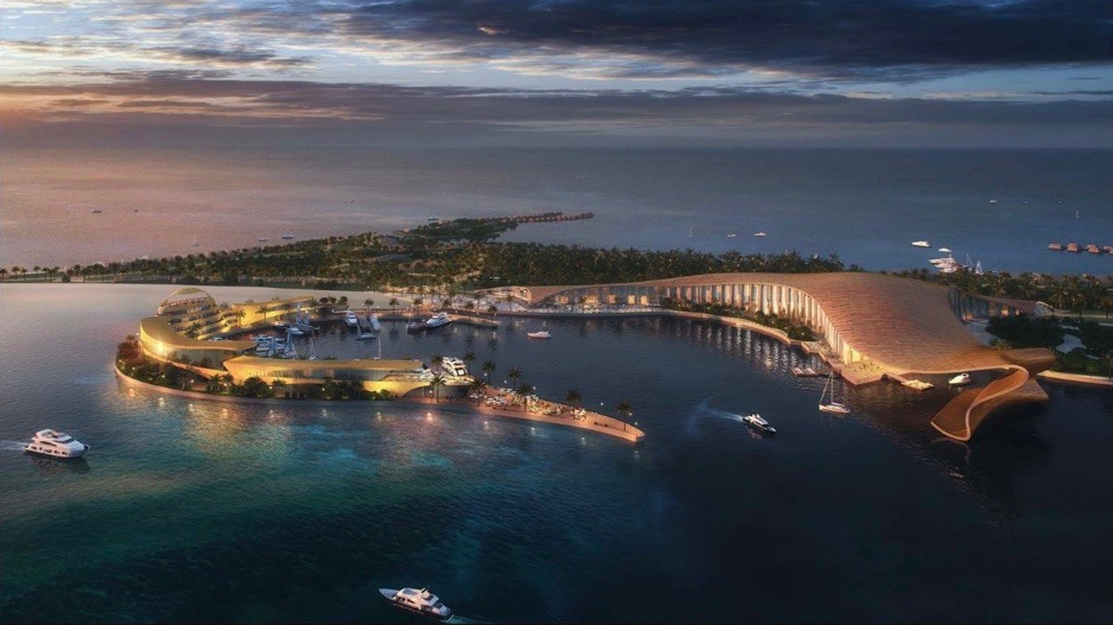 Futuristic island resort with yachts at sunset, featuring curved architecture over water.