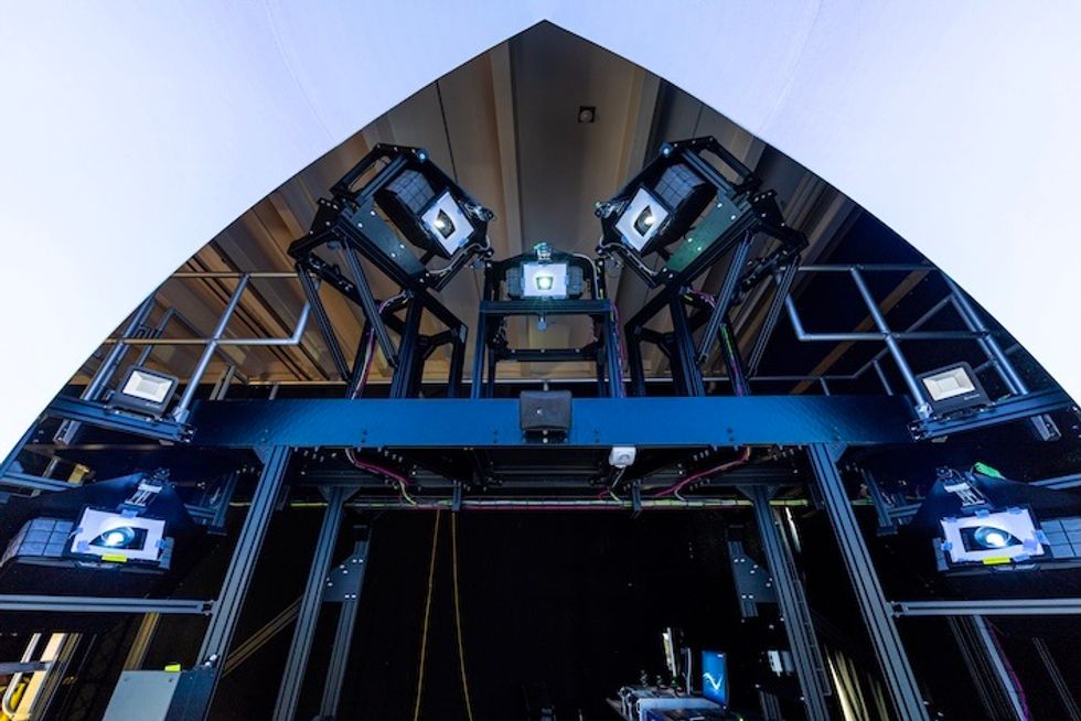 Futuristic projection equipment setup with projectors from Norxe in a dark room, viewed from below.