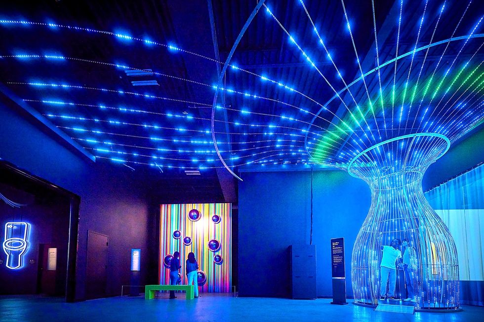 Futuristic room at Prototype: The Experimental Museum with blue LED lights and an interactive display shaped like a mushroom.