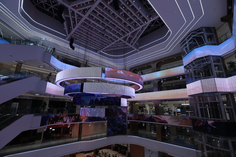 Futuristic shopping mall interior with colorful lights and circular displays.