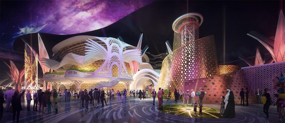 Futuristic theme park at night with illuminated architectural structures and people.