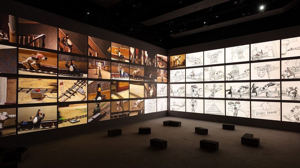 Gallery wall displaying animation frames and storyboards with viewing stools in the foreground.