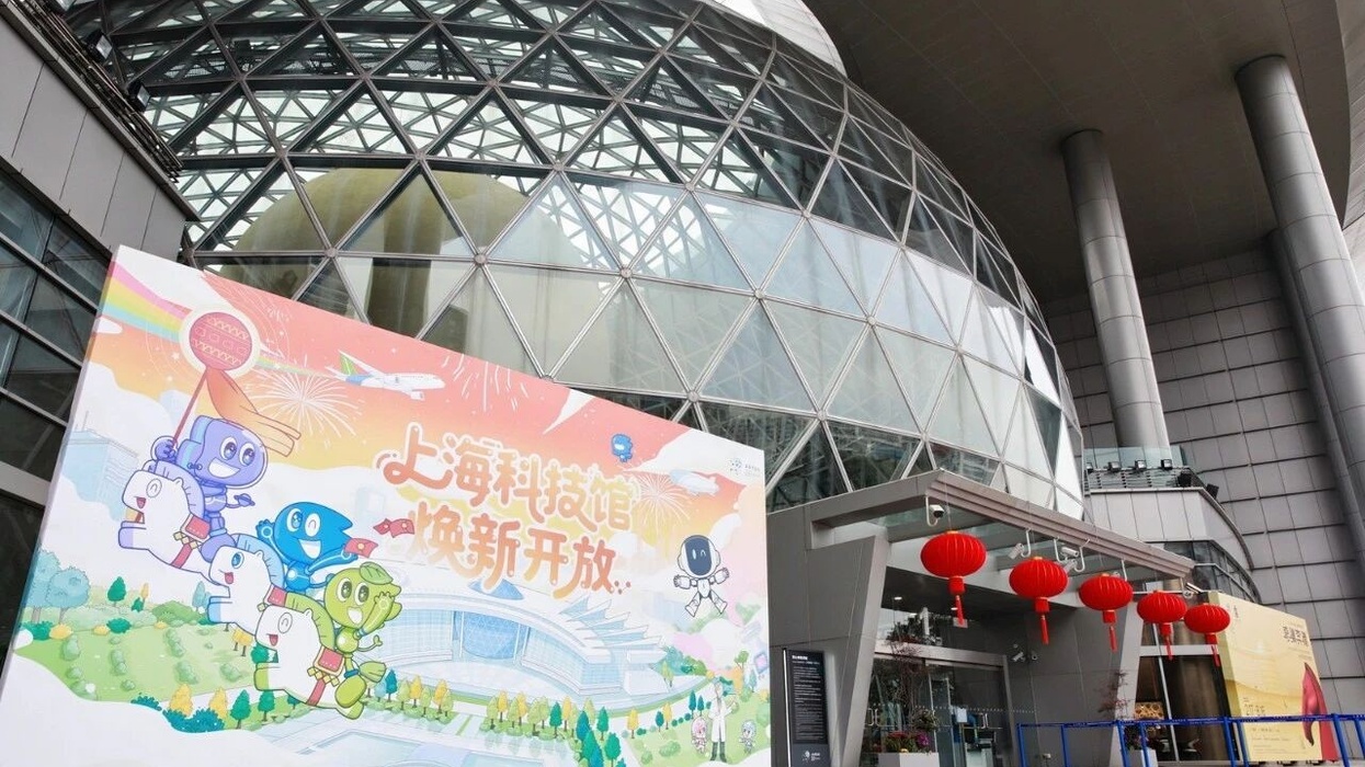 Geodesic dome entrance with colorful cartoon banner and red lanterns outside.
