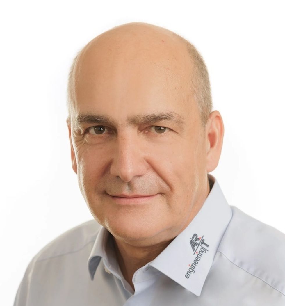 Georg Behringer, managing director of ART Engineering. Bald man in a collared shirt with logos, looking at the camera against a white background.