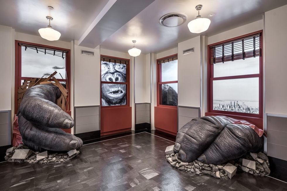 Giant gorilla hands and face or King Kong breaking through windows in a themed room at Empire State Buiding