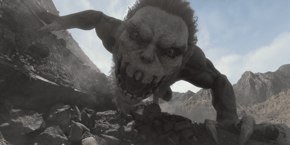 Giant humanoid creature roaring in a rocky landscape under a blue sky.