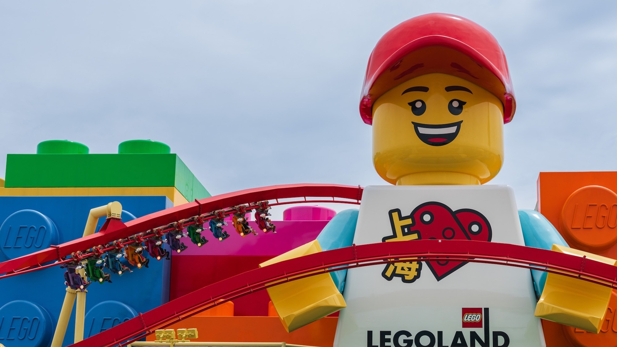Giant Lego figure at Legoland Shanghai with a roller coaster and colourful Lego blocks in the background.
