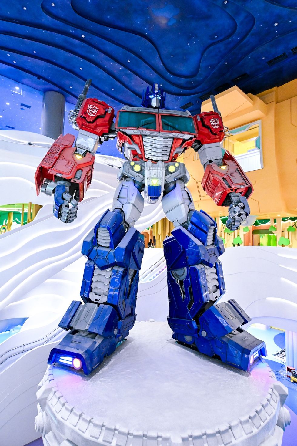 Giant robot statue with blue and red armor in a brightly lit indoor setting.