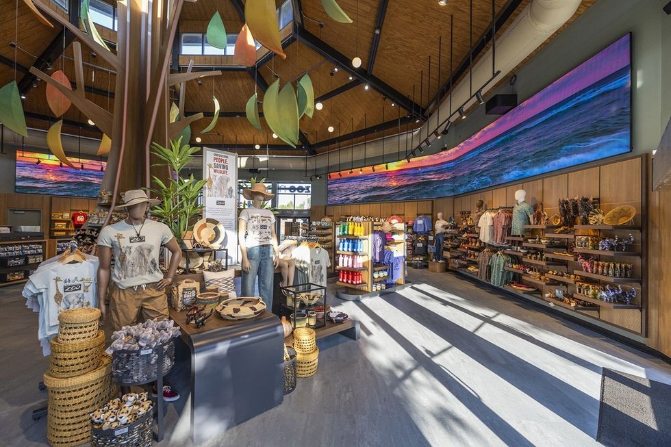 Gift shop at Columbus Zoo with colourful displays and a large beach-themed screen above.