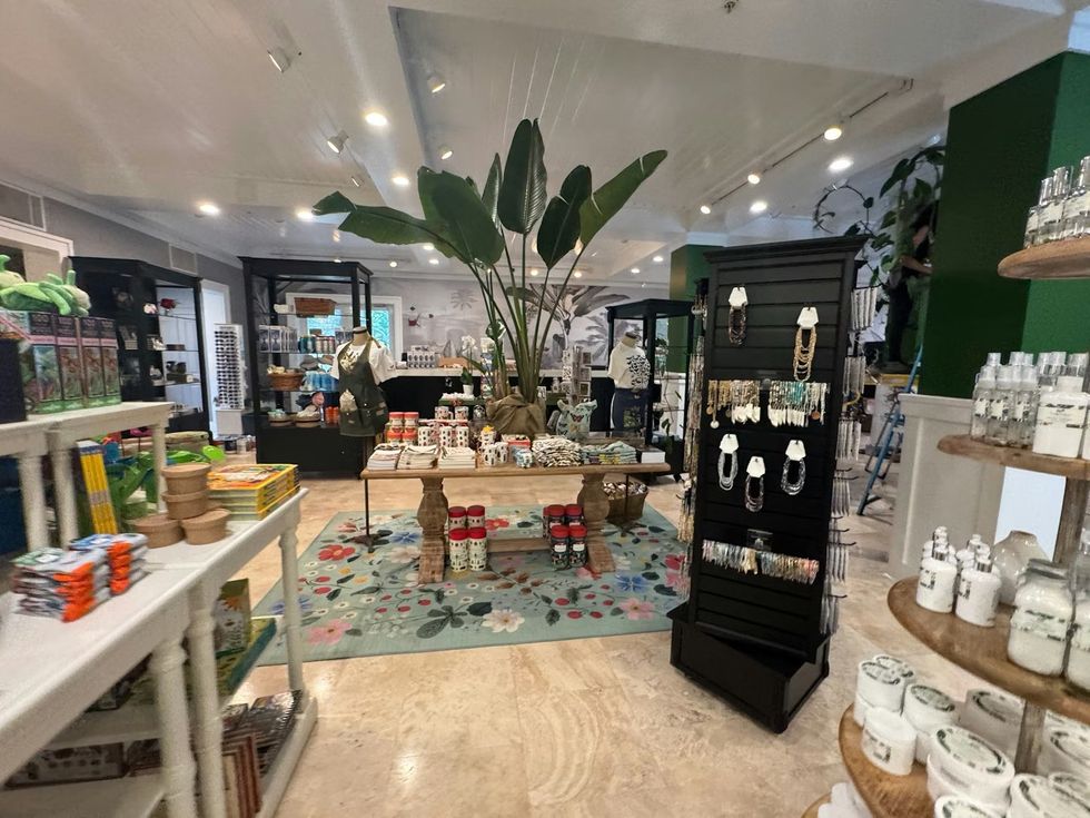 Gift shop with plants, jewelry, and decorative items on display in a bright setting. The Sanctuary Shop at Fairchild Tropical Botanic Garden