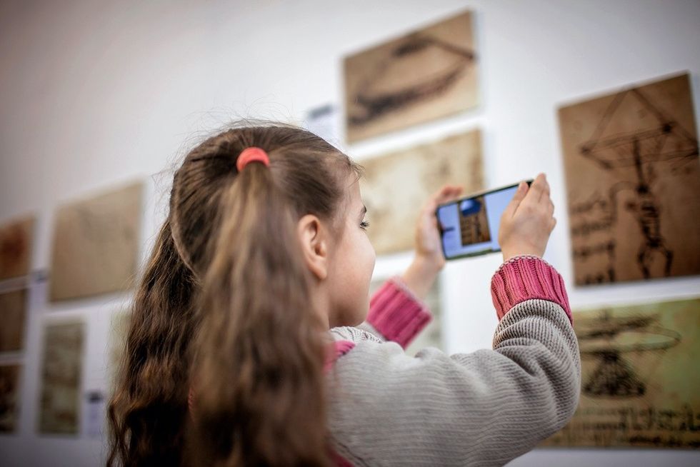 Girl-looking-at-museum-object-through-smartphone