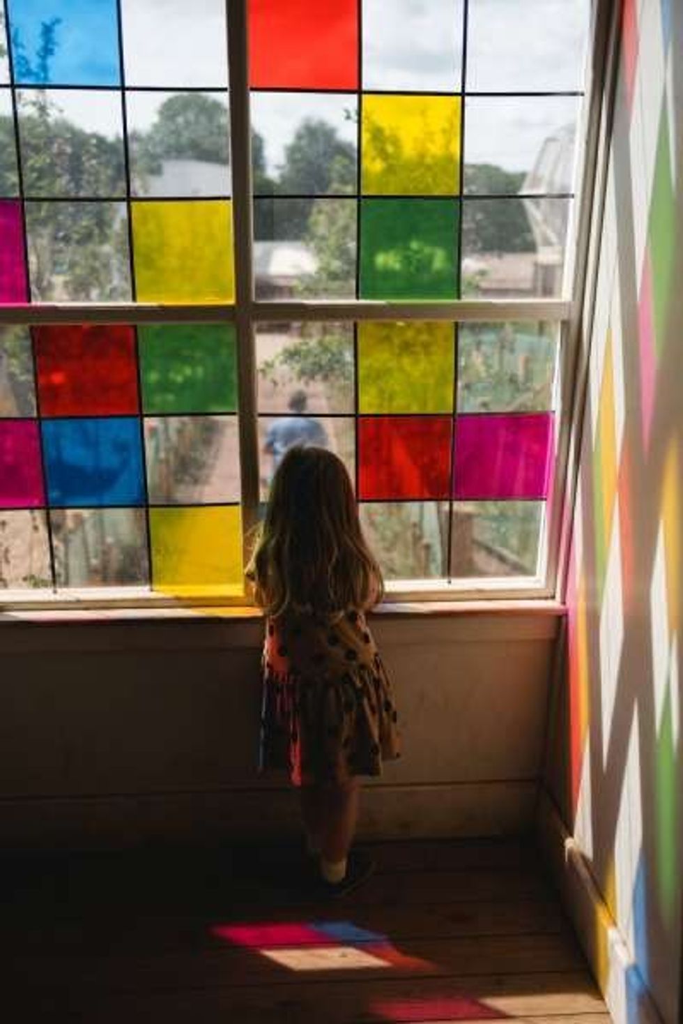 girl looks through stained glass at weehailes at newhailes house