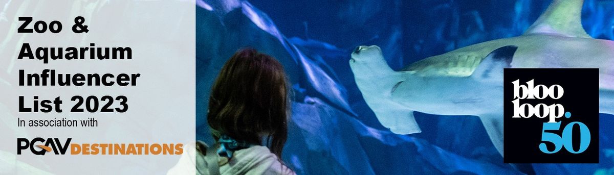 Girl standing in front of Sharks at Georgia Aquarium B50 Zoo & Aquarium Influencer List