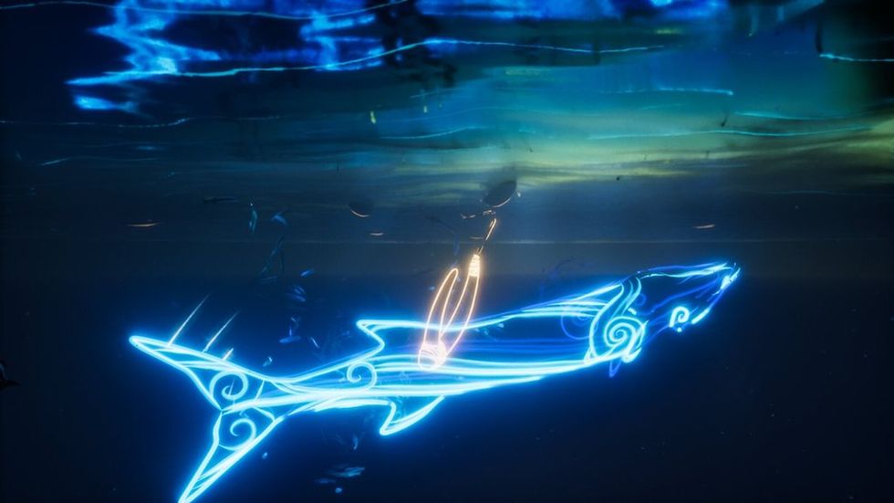 Glowing blue shark outline with neon swirls underwater at night.