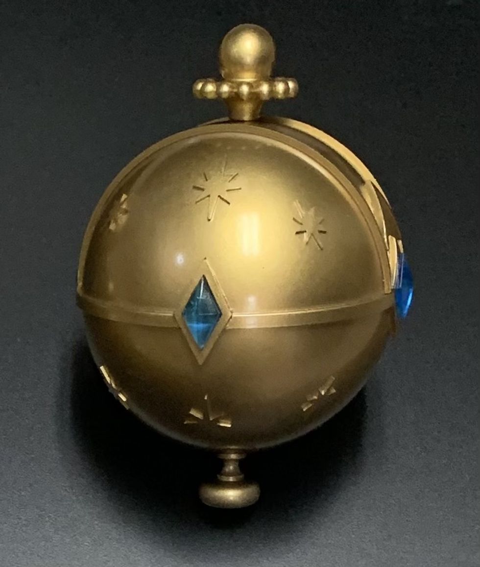 Golden orb with engraved stars and blue diamond-shaped inlays on a black background.