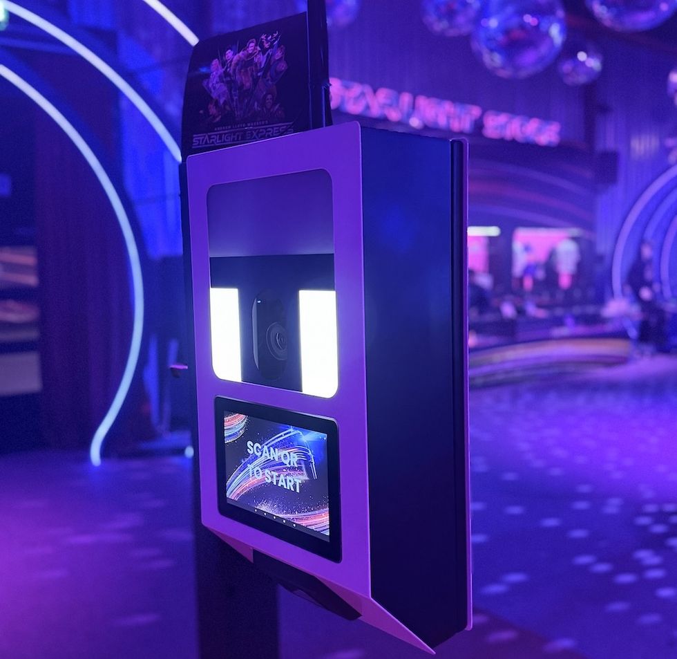 GoPhoto booth screen in a neon-lit venue displaying "SCAN QR TO START." At Starlight Express show