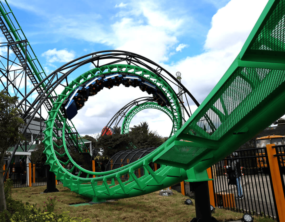 Green roller coaster loop under a blue sky with clouds at Salitre M\u00e1gico
