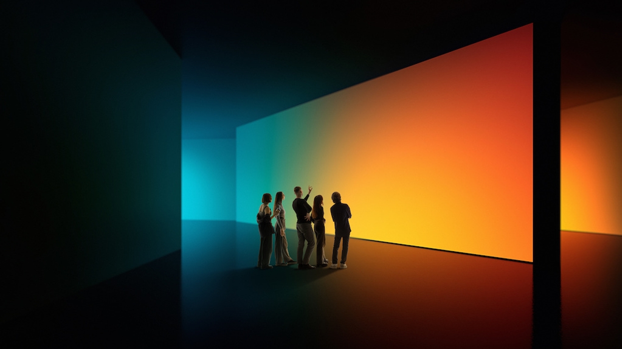 Group admiring large, gradient-lit walls in a dark room.
