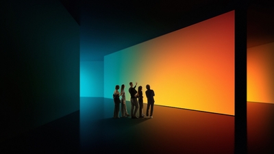 Group admiring large, gradient-lit walls in a dark room.
